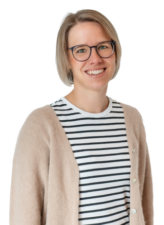Eine lächelnde Frau mit Brille trägt ein gestreiftes Shirt und eine beige Strickjacke vor weißem Hintergrund.