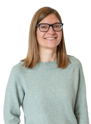 Eine Frau mit Brille und hellem Pullover lächelt herzlich in die Kamera.